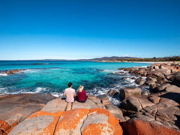 Sit on the rocks at Bay of Fires Tasmania