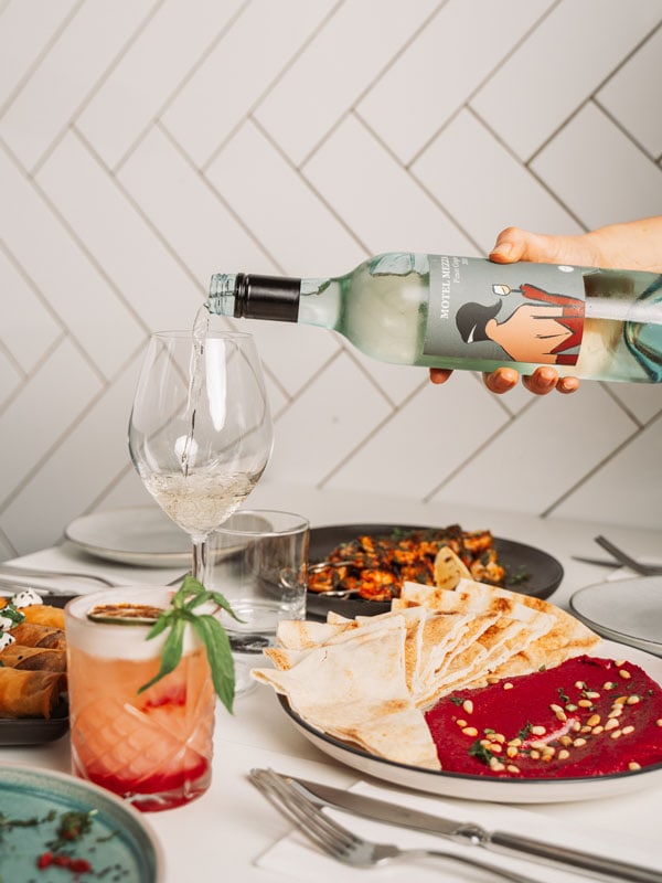 Wine is poured over a banquet of food at Motel Mezza in Wyong