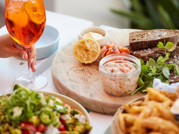 Couple enjoy an Aperol Spritz and share plates at The Boathouse Patonga