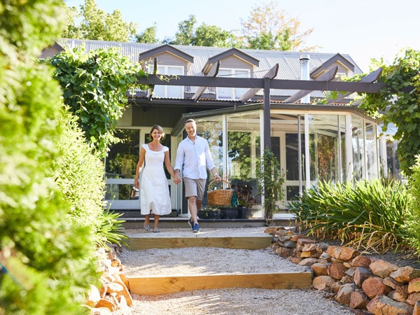 a couple walking outside a country cottage at Evanslea, Mudgee