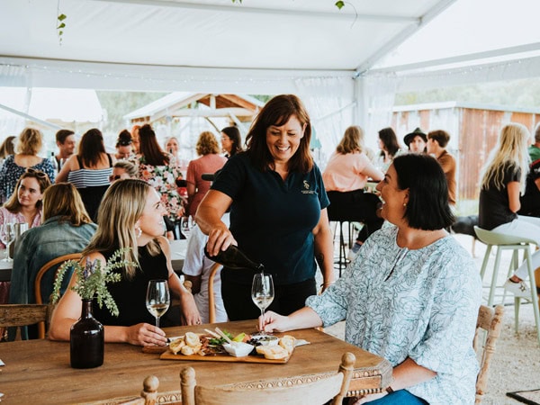 A woman pours a wine tasting for two women at Robert Stein in Mudgee