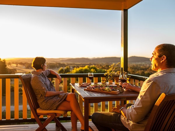 a couple dining on the verandah of Mudgee Homestead Guesthouse at sunset