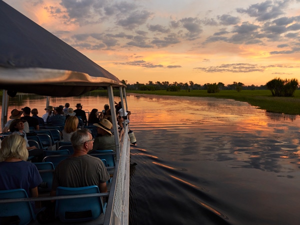 a group of travellers on a Yellow Water Billabong Cruise at sunset