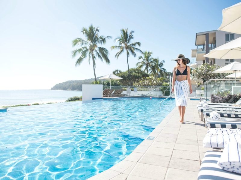 Woman walking by the pool at Tingirana Noosa