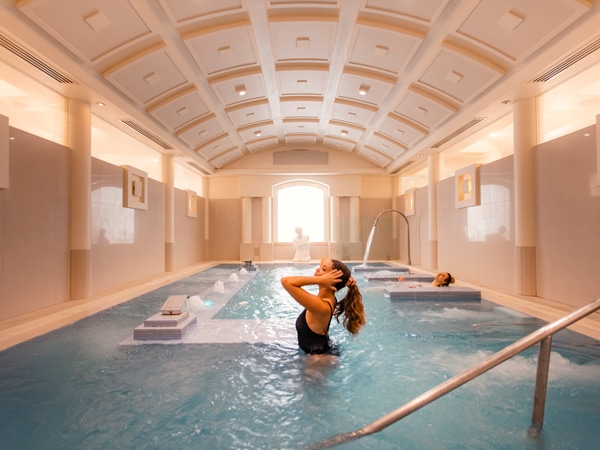 a woman swimming at the indoor pool in Noosa Springs Golf and Spa Resort