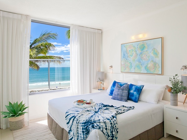 a bedroom with balcony facing the beach, On The Beach Noosa Resort