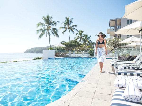 a woman walking on the side of the infinity pool at Tingirana Noosa