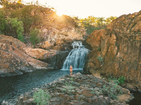 a woman standing in front of Edith Falls at Nitmiluk National Park