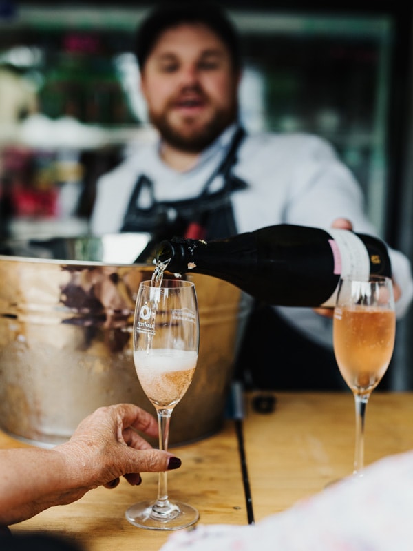 A waiter pours champagne at Festivale in Launceston, Tasmania. (Image: Adam Gibson)