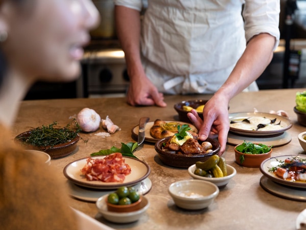 a chef preparing tapas for diners at Una Más restaurant on the middle level of the Coogee Pavilion, Coogee