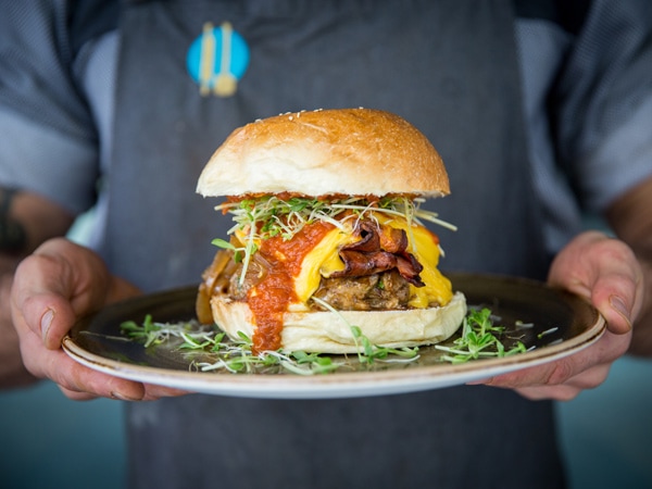 a person holding a burger at Patissez, Canberra