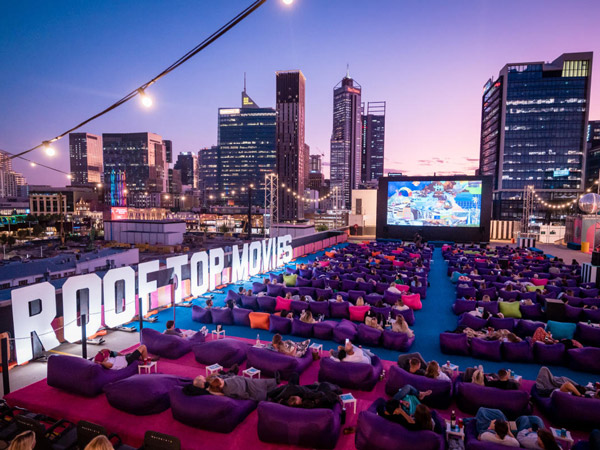 people reclining in deck chairs while watching at the Northbridge Rooftop Movies
