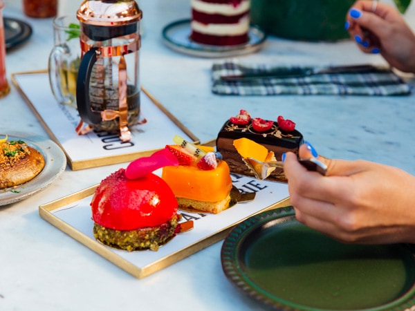 a hand getting a fork bite of dessert at The Grounds of Alexandria