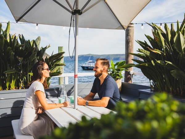 a couple sitting under a huge umbrella at The Boathouse, Palm Beach