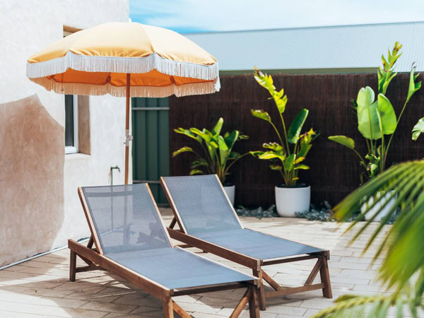 sun loungers under a yellow umbrella at BASK, Robe