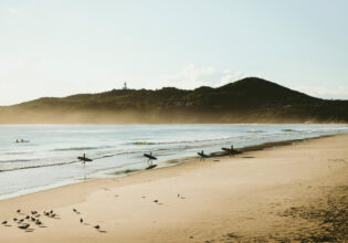 surfers at sunrise on Belongil Beach, Byron Bay