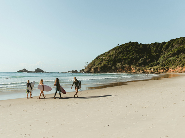 surfers walking along Broken Head Beach, Byron Bay