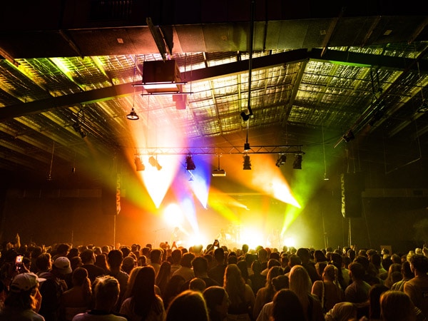 a crowd of people watching a live performance at Dreamworld Night Market