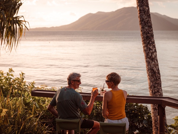 a couple enjoying a cocktail at Foxy’s Bar & Cafe overlooking Fitzroy Island