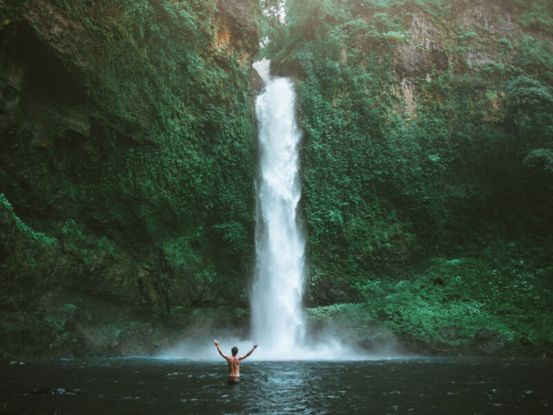 a man standing in front of Nandroya Falls, Cairns
