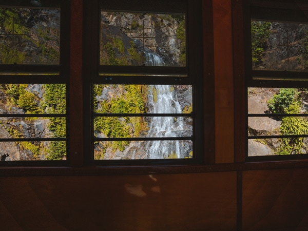 train windows peeking through a waterfall at Kuranda Scenic Railway