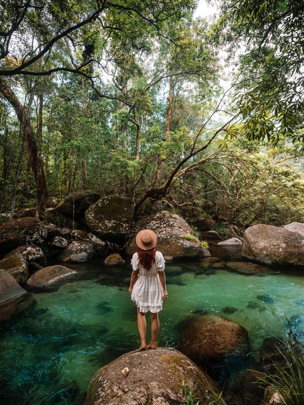 a young woman at rainforest creek at Mossman Gorge