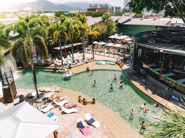 a top view of people enjoying at the huge outdoor pool area of Gilligan’s Hotel and Resort, Cairns
