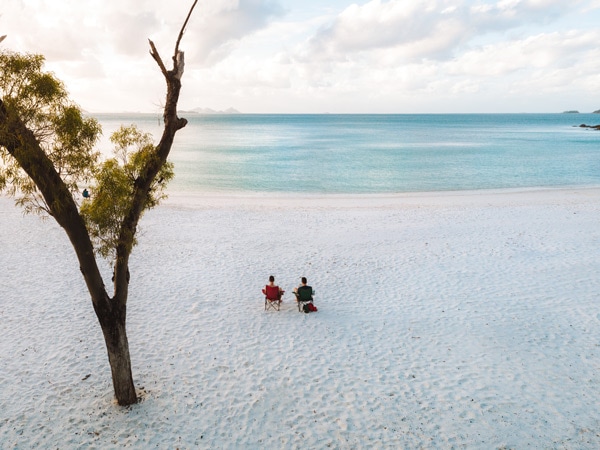 Pasangan duduk di Pantai Whitehaven