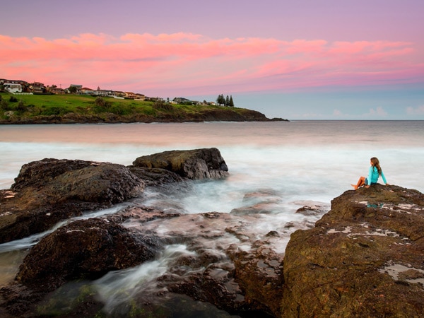 a little girl sitting on the beach rock, Easts Beach BIG 4 Holiday Park