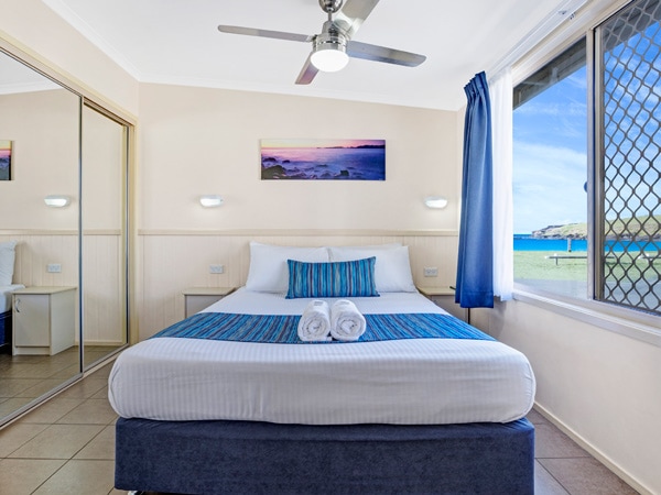 a bedroom with a window inside the beach retreat at Easts Beach BIG 4 Holiday Park