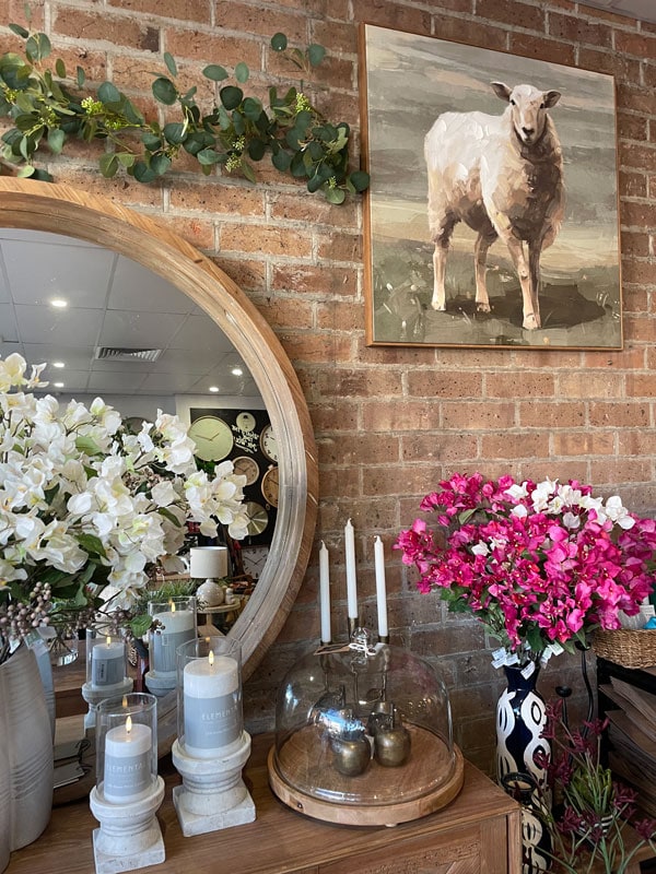 flowers, candleholders and a wall painting inside Mary and Tex Curious Emporium shop in Orange 