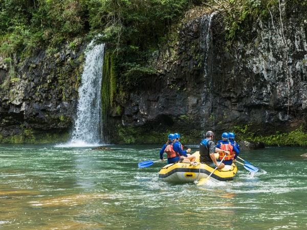 passing by a stunning waterfall while rafting with Raging Thunder Adventures