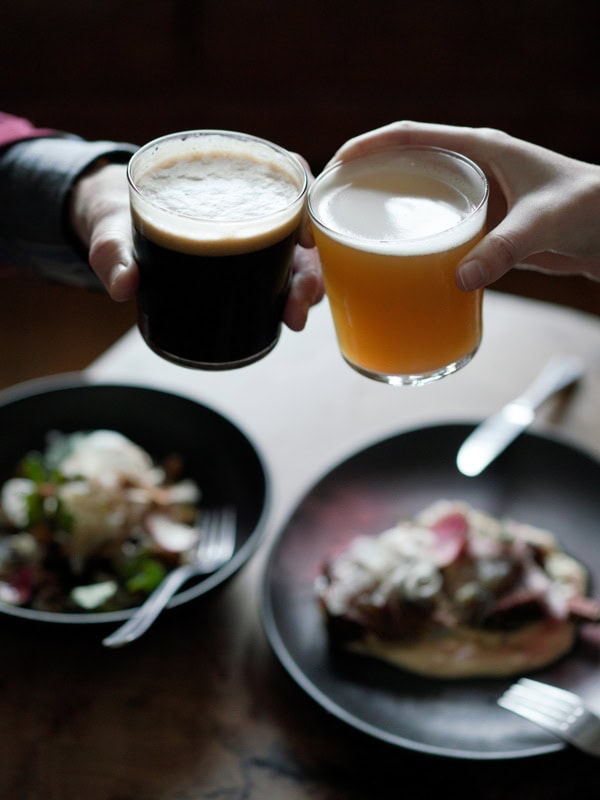 hands clinking drinks at Resin Brewing, Bulli