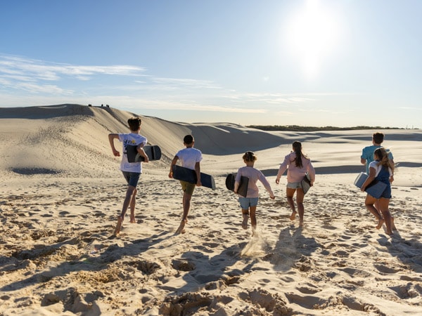 a family enjoys sandboarding