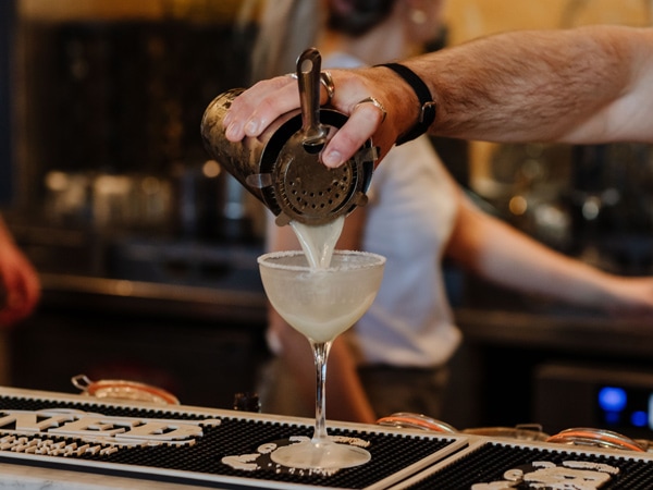 a hand pouring a drink into a glass at Customs House Hotel, Newcastle