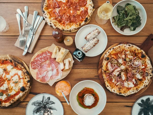a table-top view of the menu and pizza at Stef Beachstone, Coffs Harbour