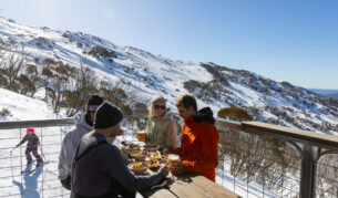 friends dining on the outdoor deck of Black Sallees, Thredbo