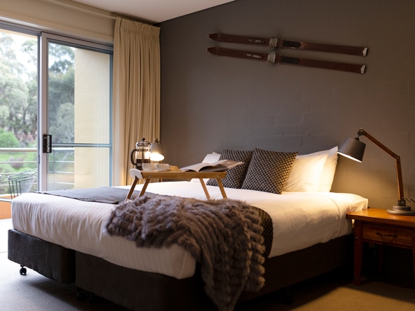 a bedroom with a balcony at Lake Crackenback Resort & Spa, thredbo