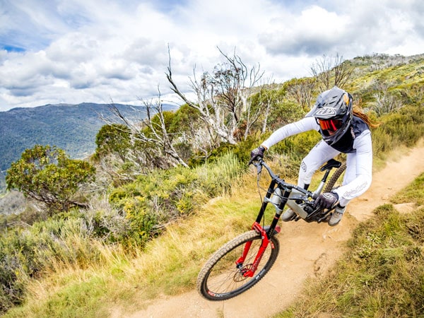 a female biker navigating the rugged terrain at Thredbo Mountain Bike Park