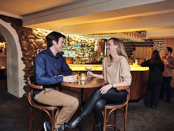 a couple enjoying cocktails at the Apres Bar at The Denman Hotel,Thredbo in the Snowy Mountains