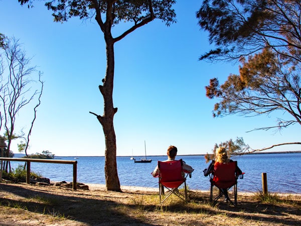 two people sitting on a foldable camping chair at Boreen Point Campground