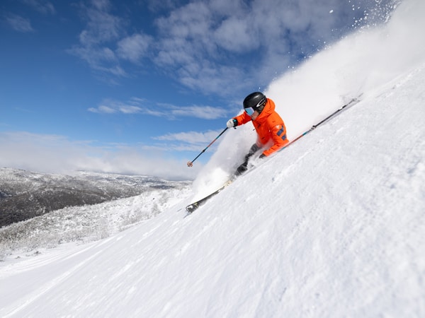 a person skiing in the snowy mountains on the Ikon Pass