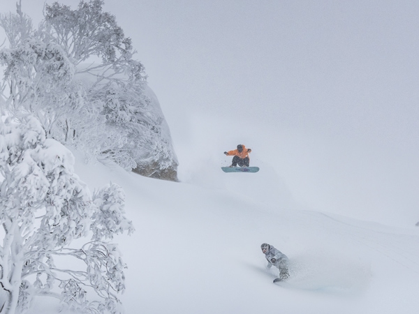 two people enjoying skiing in the snowy mountains on the Ikon Pass