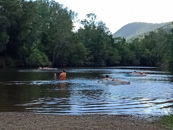 people soaking in a river at Lake Borumba Caravan & Camping Grounds