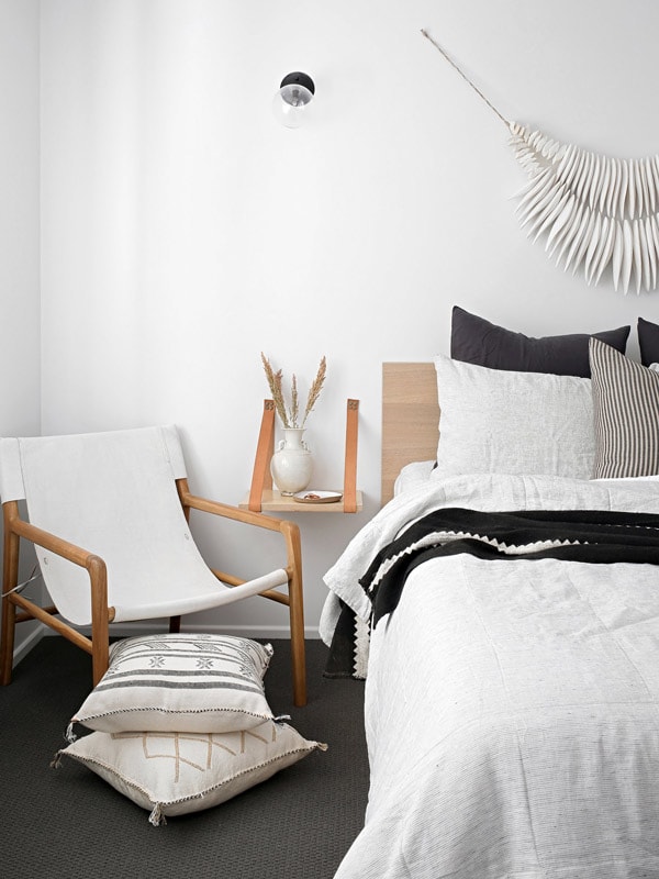 a bed beside a chair at The Lodge, Noosa Heads
