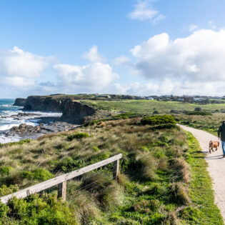 a man walking with a dog along the George Bass Coastal Walk, Phillip Island