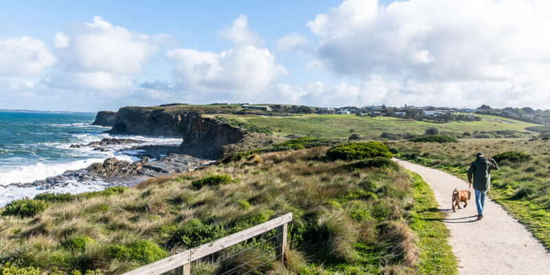 a man walking with a dog along the George Bass Coastal Walk, Phillip Island