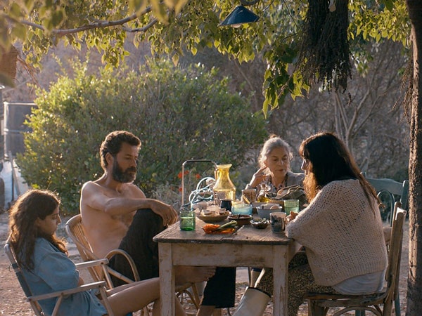 A family sitting at a table outside.