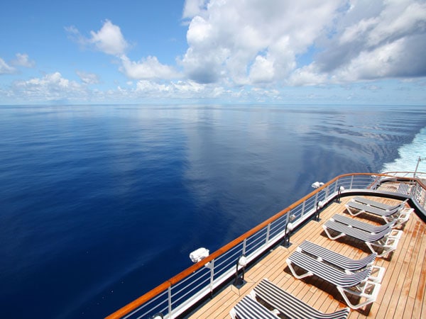 Cruise ship deck with sunchairs and a calm ocean view