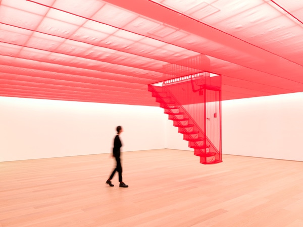 Someone walking around a pink space with a roof and stairs.